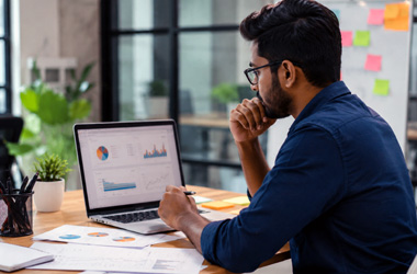 Advertisement Services Digital marketing professional analyzing online campaign performance and SEO strategy on a laptop in a modern corporate office for business growth.